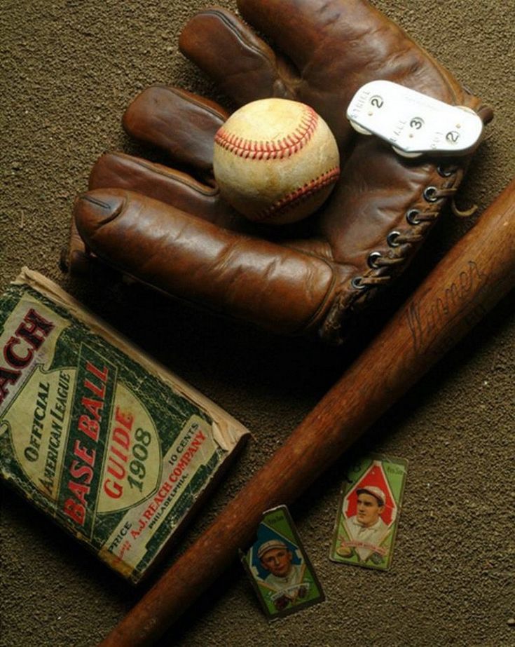 an old baseball bat, glove, and ball sitting on the ground next to some other items