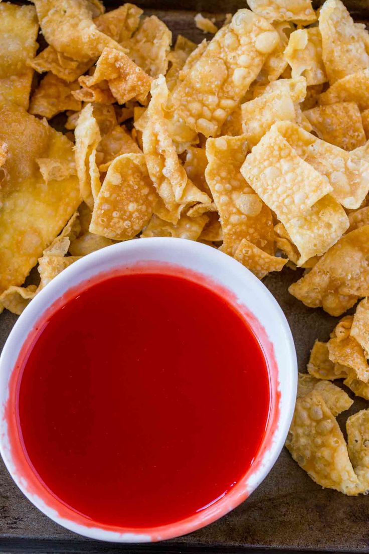 a bowl of red sauce next to some tortilla chips