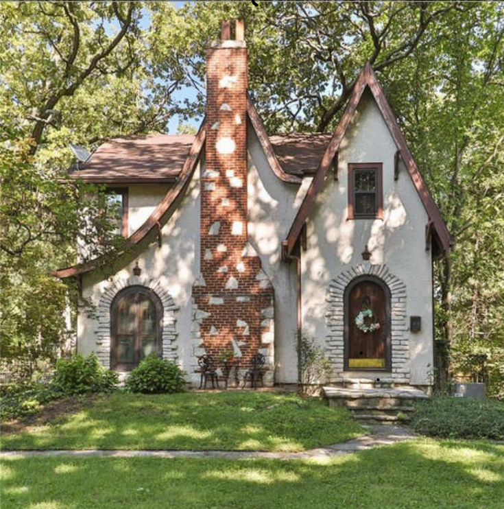 a white house with brown shingles in the front yard