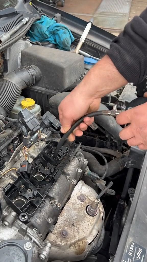 a man working on an engine in his car