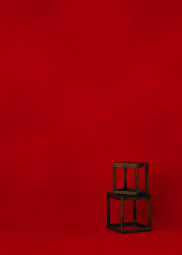 a small wooden chair sitting on top of a red floor in front of a red wall