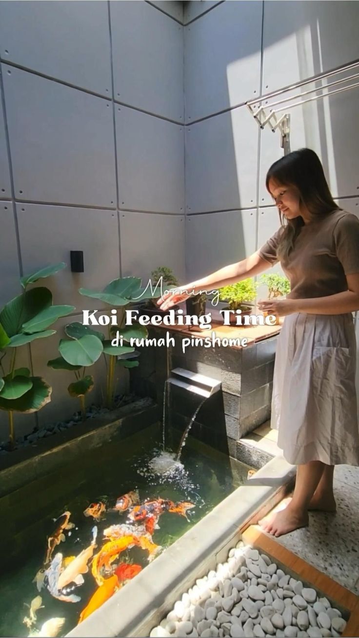 a woman standing in front of a fish pond