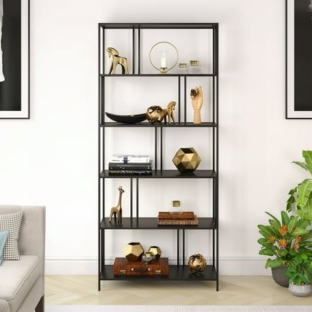 a living room with a couch, chair and shelving unit in front of a white wall