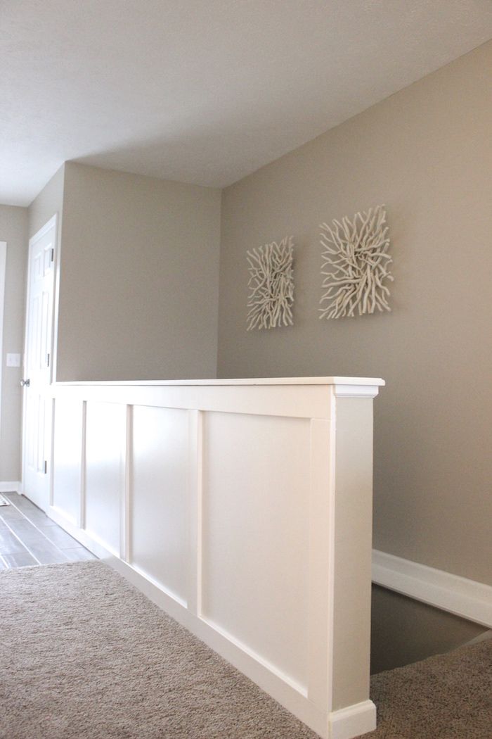 an empty living room with carpeted flooring and two white framed pictures on the wall