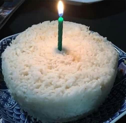 a white cake with a single candle on it sitting on a blue and white plate