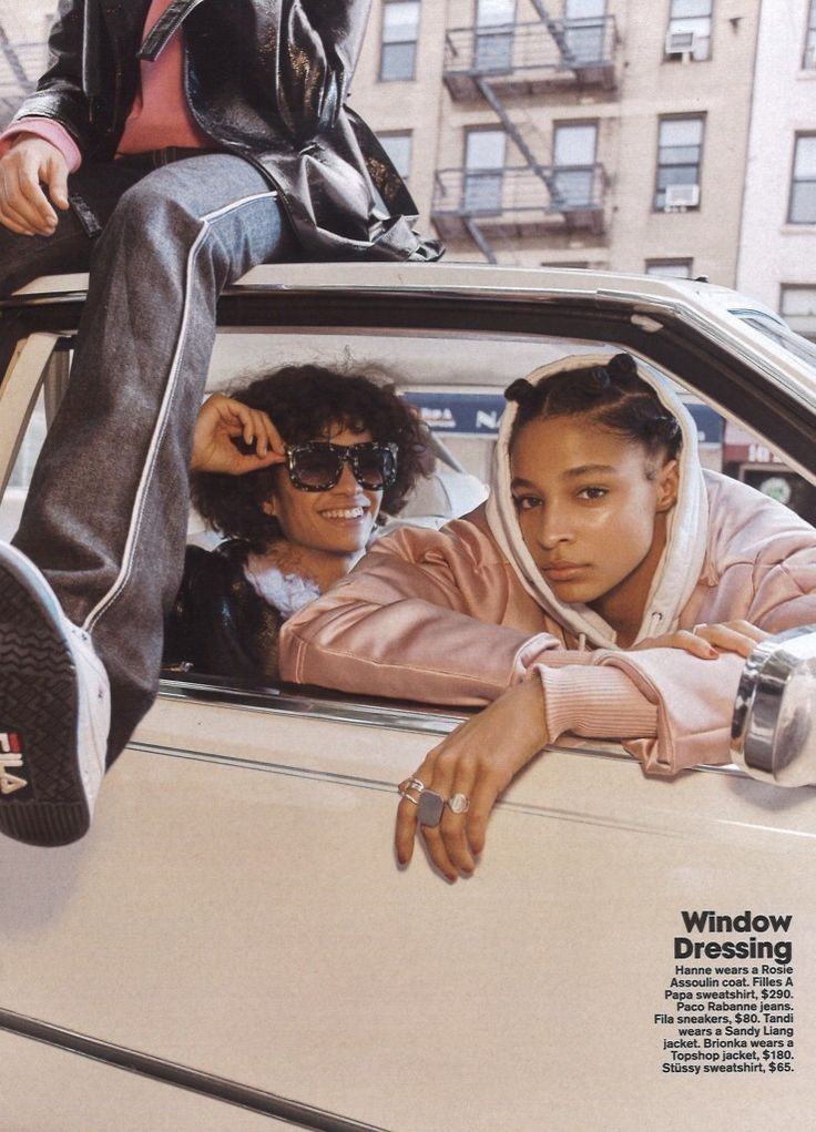 two young women sitting in the back of a car