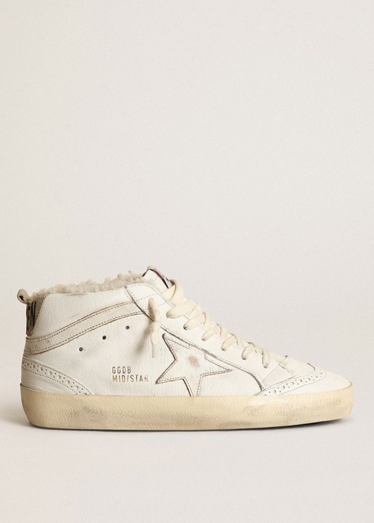 Kick your sneaker game up a notch with the Golden Goose Deluxe Brand Mid Star Shearling Sneakers. These playful kicks feature a shearling lining and padded collar for ultimate comfort, while the signature distressed upper adds a unique, lived-in look. With wingtip brogue details and a star and perforation design, these sneakers are sure to make a statement. Available in White/Beige Upper: 86% Goat Leather, 14% Cow Leather Lining: 88% Ovine Leather, 12% Cow Leather Sole: 100% rubber Handcrafted M High Star Golden Goose, Golden Goose Shearling, Golden Goose Sabot Shearling, Perforation Design, Golden Goose Leopard Mid Star, Golden Goose Sky Star, The Golden Goose, Fall Outerwear, Sneakers Street Style