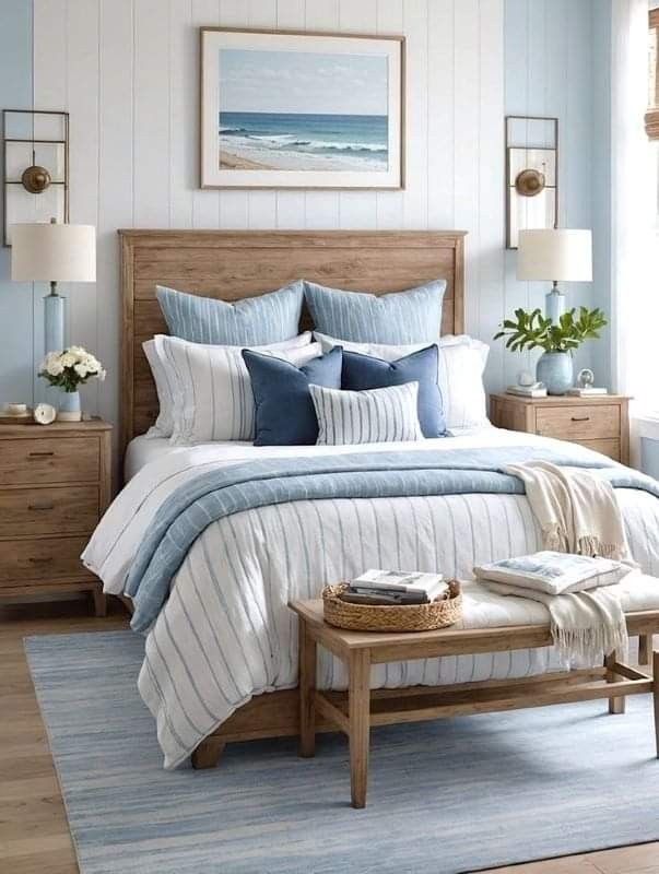 a bedroom with blue and white bedding, wooden furniture and paintings on the wall