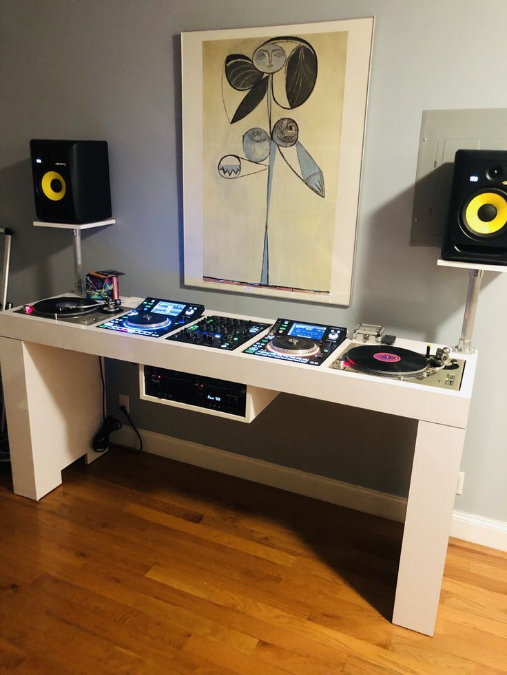 there is a table that has some dj's on it and speakers in front of it