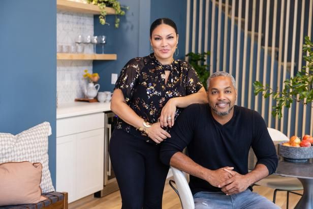 a man and woman are sitting at a table in the living room with blue walls