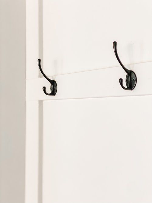 two black hooks on the side of a white door