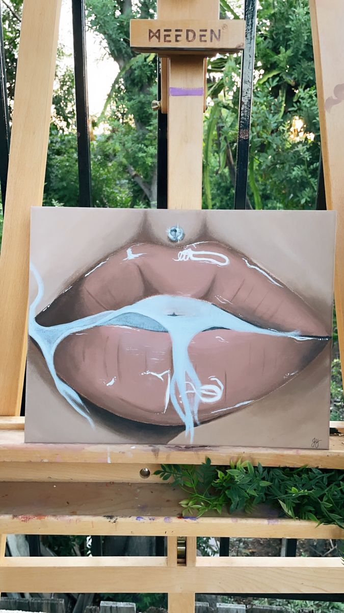 an easel with a painting of a woman's lips on it