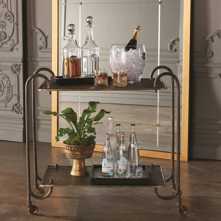 a bar cart with bottles and glasses on it