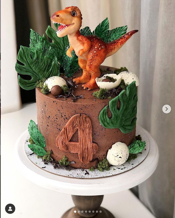 a birthday cake decorated with an image of a t - rex and plants on top