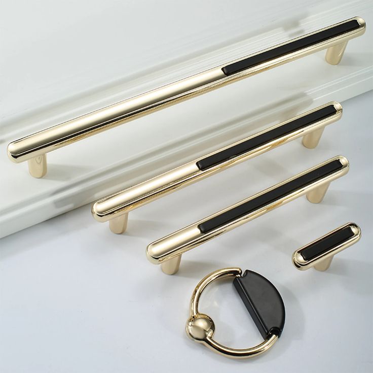 an assortment of door handles and pulls on a white surface with a black ring in the middle