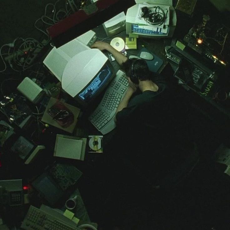 a person sitting in front of a laptop computer on top of a desk covered in clutter