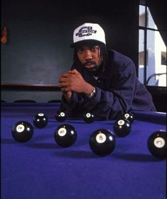 a man leaning over a pool table with eight balls