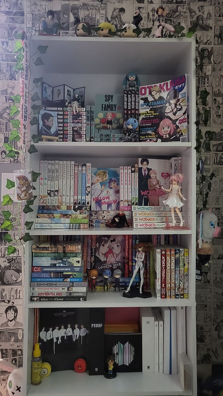 a book shelf filled with lots of books next to a wall covered in cartoon characters