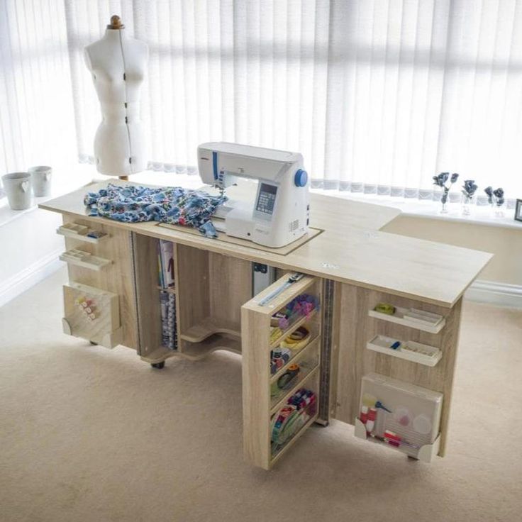 a sewing machine sitting on top of a wooden desk next to a white dressmaker