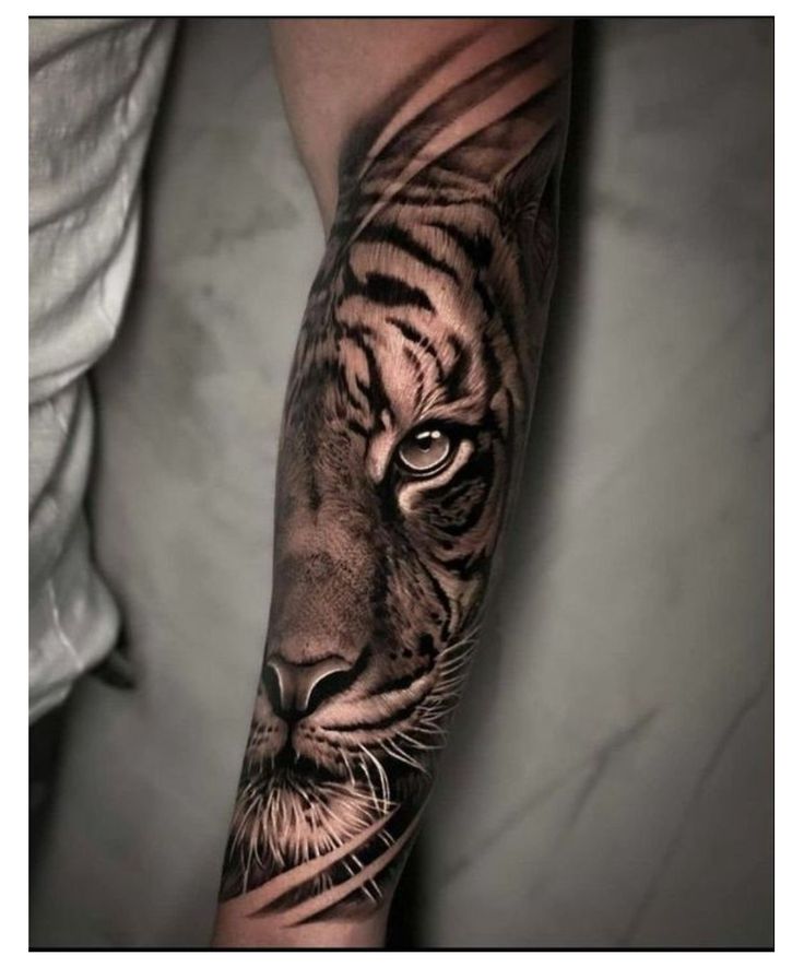 a man's arm with a tiger tattoo on it