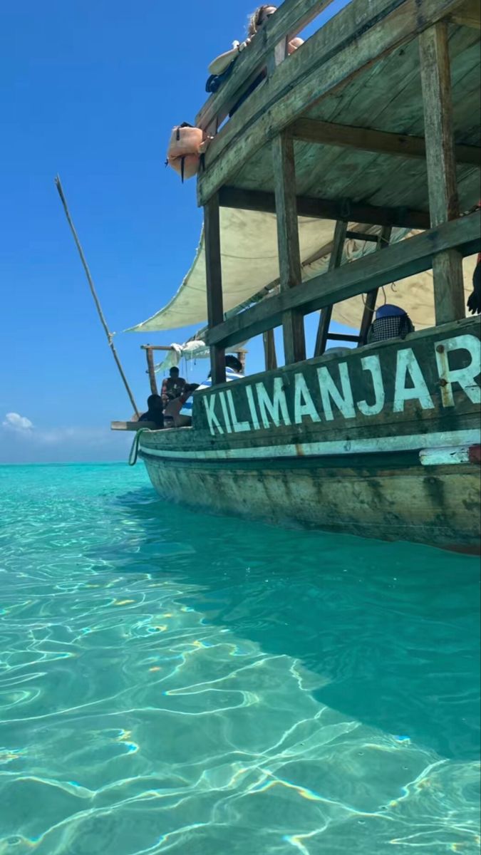 a boat that is sitting in the water with people on it's back end