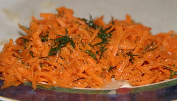 a plate with carrots and herbs on it