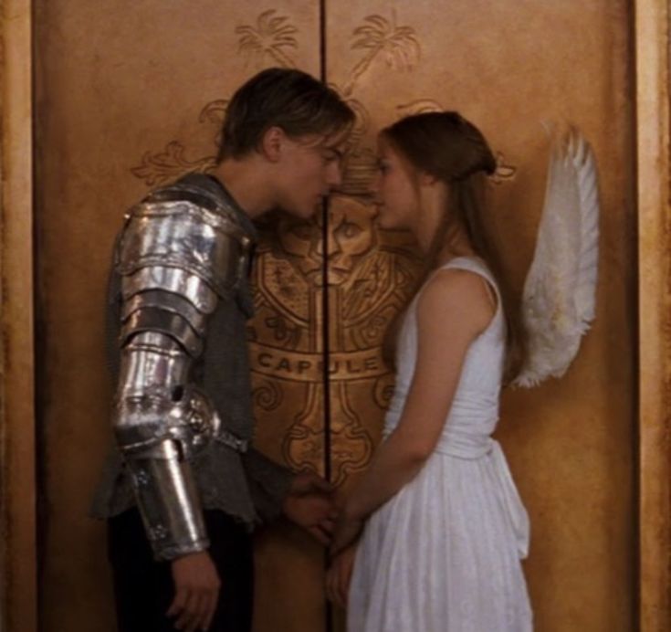 a man and woman dressed in armor standing next to each other near an open door