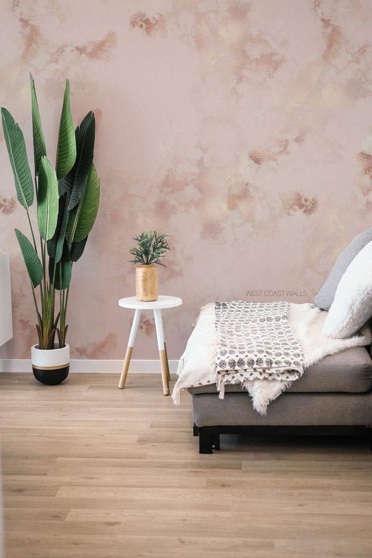 a living room with a couch, table and potted plant on the floor next to it