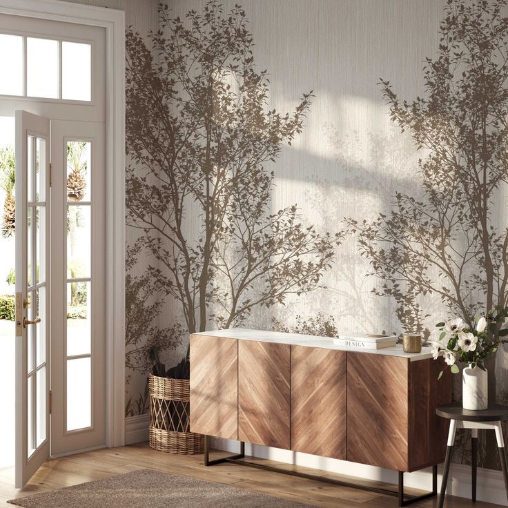 a bathroom with a tree wallpaper on the wall next to a bathtub and sideboard