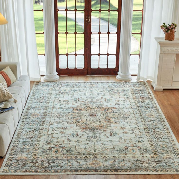 a living room with a large rug on the floor next to a couch and door