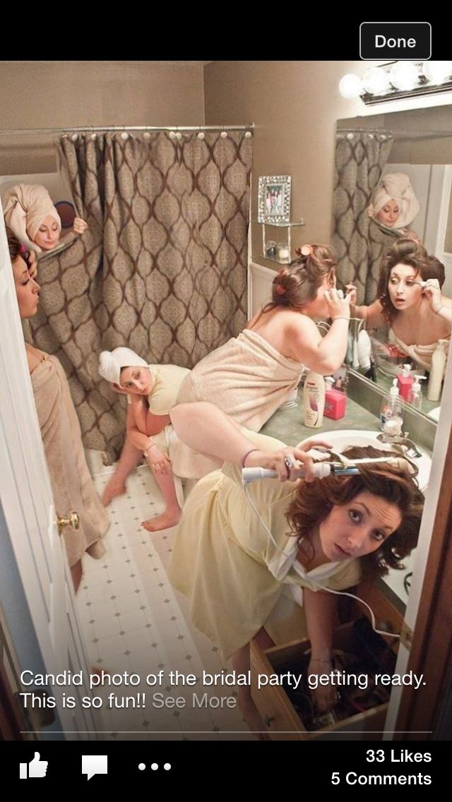 a woman in a bathrobe looking at herself in the mirror with other women around her