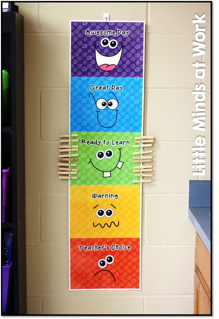 a bulletin board with five different colors and faces on it, hanging from the wall