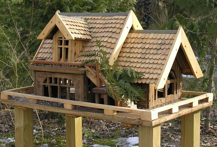 a toy house made out of wood with plants growing in the roof and on top