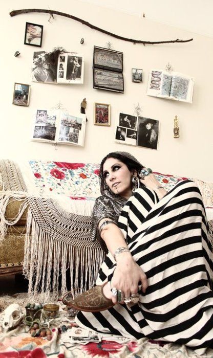 a woman sitting on top of a couch in a living room next to a wall