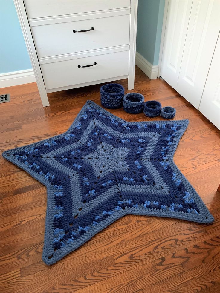 a blue crocheted star rug and slippers are on the floor in front of a dresser