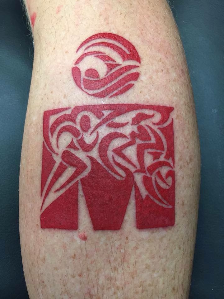 a red and white tattoo design on the leg