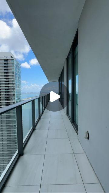 an empty balcony overlooking the ocean and high rise buildings