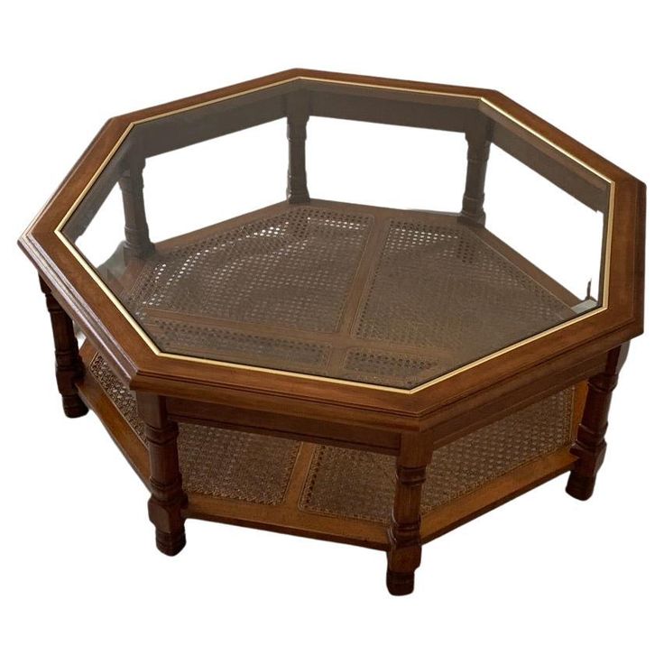 an octagonal wooden coffee table with glass top and caned legs, on display against a white background