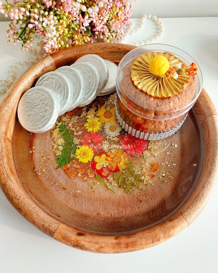 a wooden tray with flowers and cookies on it