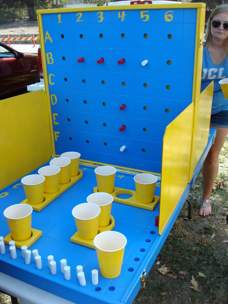 a woman standing next to a blue and yellow game