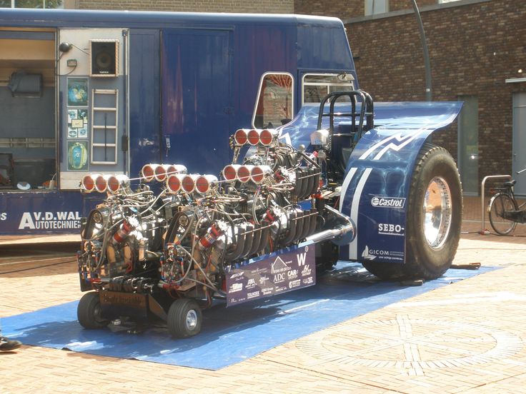 a large truck with many small engines on the back is parked in front of a building