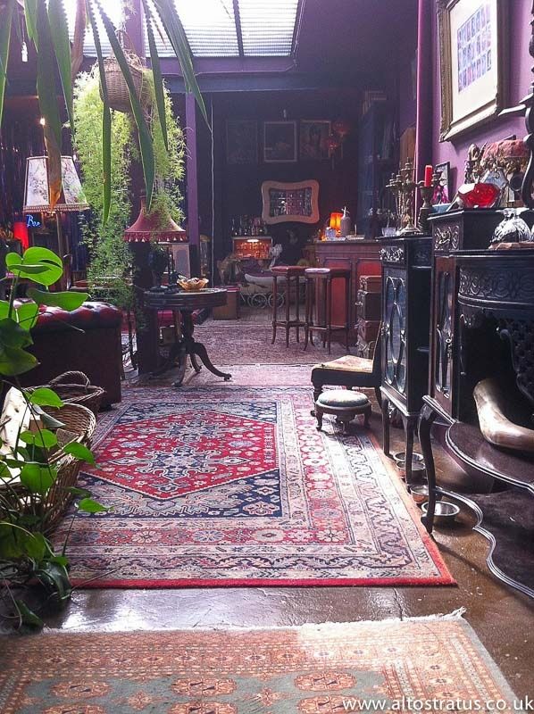 a living room filled with lots of furniture and plants