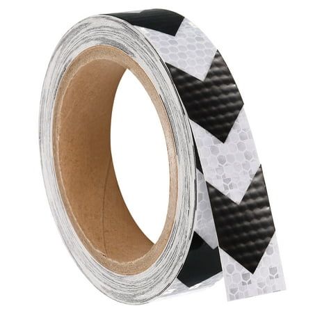 a black and white tape with an arrow pattern on the side, in front of a white background