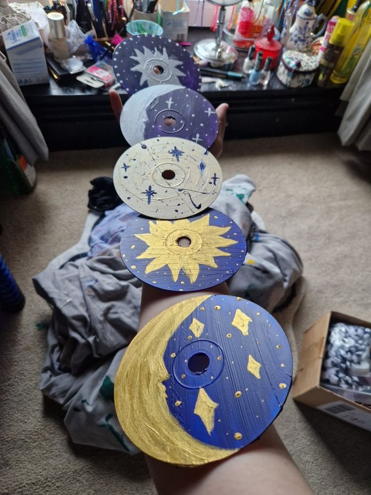 three paper plates with stars and moon designs on them, sitting in front of a mirror