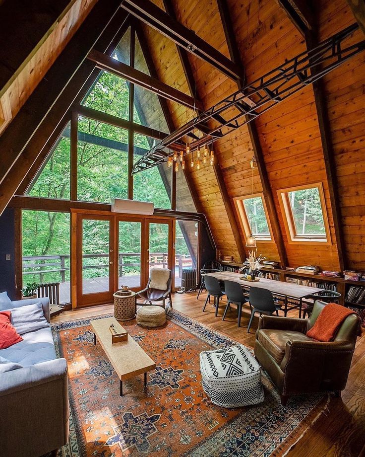 a living room filled with furniture and lots of windows on top of a wooden ceiling