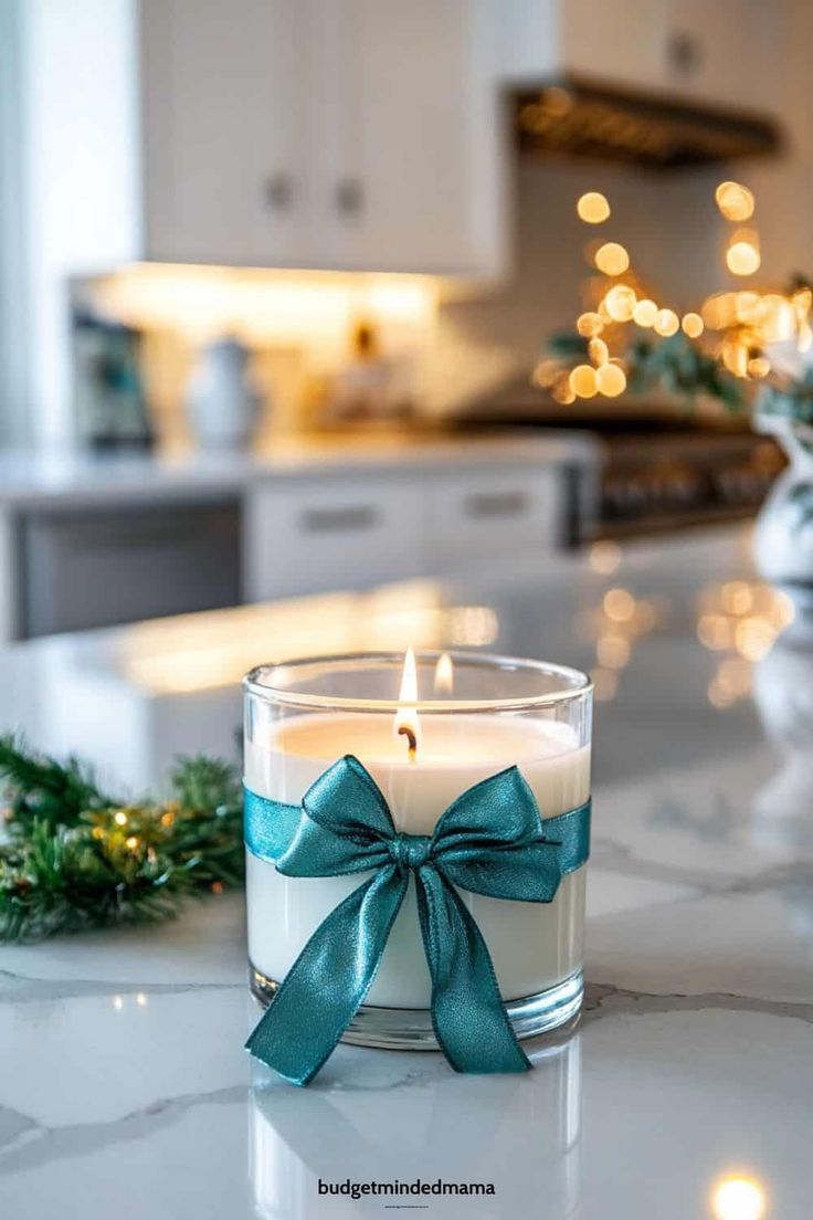 a candle that is sitting on a counter top with a bow around it's edge