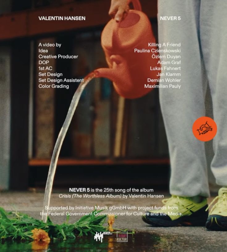 a person pouring water from a red watering can