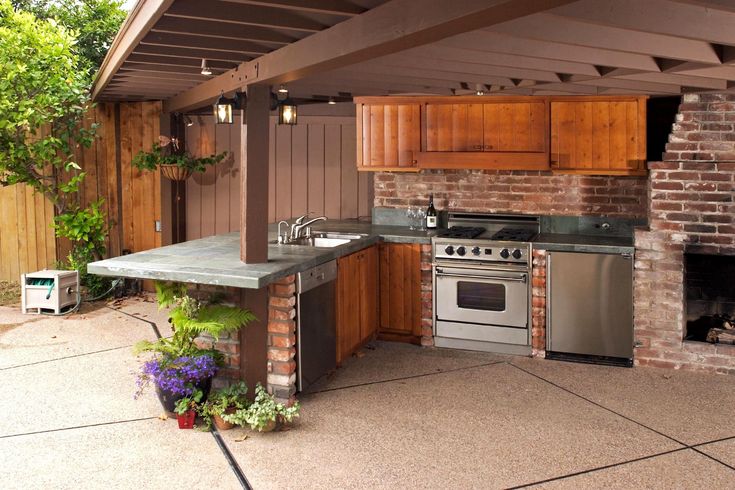 an outdoor kitchen with grill, sink and oven