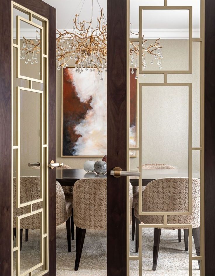 an open door leading to a dining room with a chandelier hanging from the ceiling