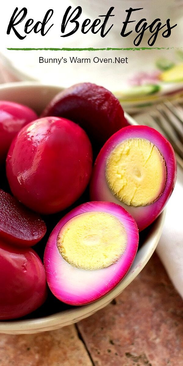 a bowl filled with red beets on top of a wooden table